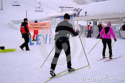 Group, skiers and snowboarders on skis at foot of snowy mountain, preparation for ascent from slope in Levi ski resort, tourism, Editorial Stock Photo