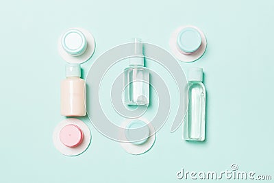 Group of small bottles for travelling on blue background. Copy space for your ideas. Flat lay composition of cosmetic products. Stock Photo