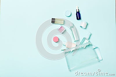 Group of small bottles for travelling on blue background. Copy space for your ideas. Flat lay composition of cosmetic products. Stock Photo