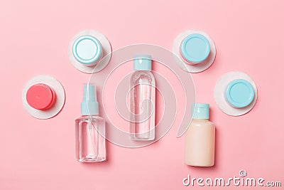 Group of small bottles for travelling on pink background. Copy space for your ideas. Flat lay composition of cosmetic products. Stock Photo