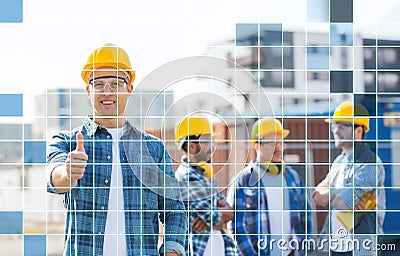 Group of smiling builders in hardhats outdoors Stock Photo