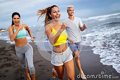 Group of sport people running on the beach Stock Photo