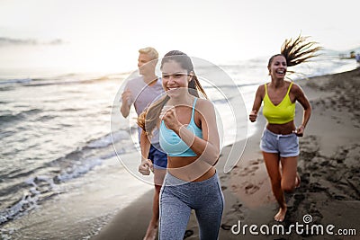 Group of sport people running on the beach Stock Photo