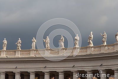 Group of statues of Peter`s Square Colonnade with rainy clouds on background, Vatican city state, Italy Editorial Stock Photo