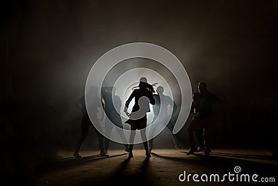 A group of street dancers performing different moves on the dark street Stock Photo