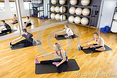 Group stretching exercises for muscle flexibility at fitness center Stock Photo