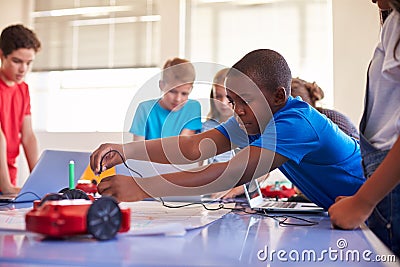 Group Of Students In After School Computer Coding Class Learning To Program Robot Vehicle Stock Photo