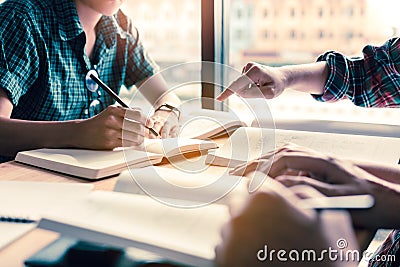 Group of students studying and brainstorming on desk in a public Stock Photo