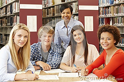 Group of students working in library with teacher Stock Photo
