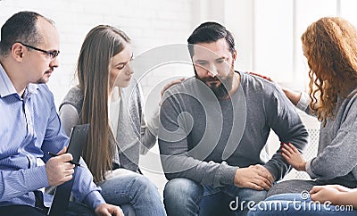 Group supporting depressed man with alcoholism problem Stock Photo