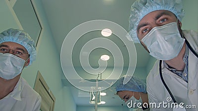 Group of surgeons looking down at patient on the way to operation room Stock Photo