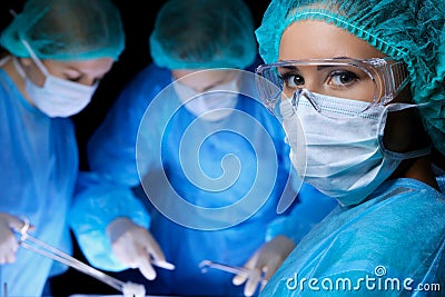 Group of surgeons in masks performing operation. Medicine, surgery and emergency help concepts Stock Photo