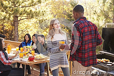 Group at a table behind two friends talking at a barbecue Stock Photo