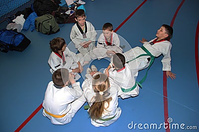 A group of taekwondo sitting on the floor for a rest. Editorial Stock Photo