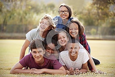 Group of teenage friends lying in a pile on grass Stock Photo