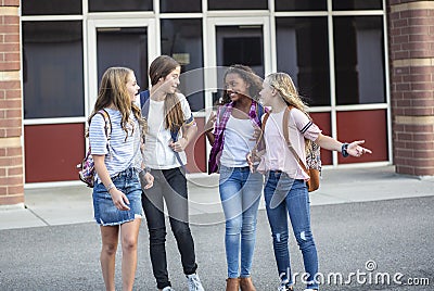 Group of Teenage girls laughing and talking together at school Stock Photo