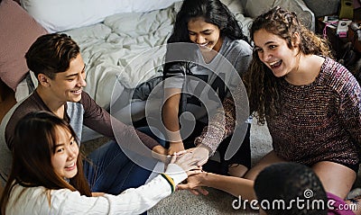 Group of teenagers in a bedroom putting their hands together community and teamwork concept Stock Photo