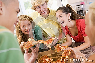 Group Of Teenagers Eating Pizza Stock Photo