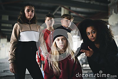 Group of teenagers gang standing indoors in abandoned building, bullying concept. Stock Photo