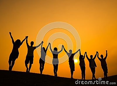 Group of Teenagers Holding Hands and Celebrate in Back Lit Stock Photo