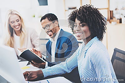 Group of three coworkers working together on business project in modern office.Young attractive african woman smiling, teamwork co Stock Photo