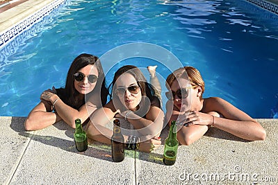 group of three happy beautiful girl friends having bath in swimming pool together having fun Stock Photo