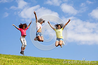 Group three jumping girls over clean blue sky Stock Photo