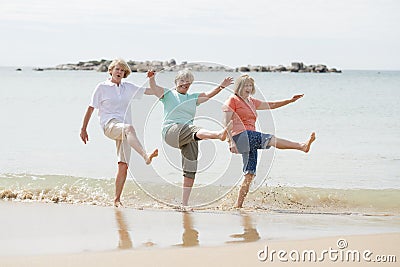 Group of three senior mature retired women on their 60s having fun enjoying together happy walking on the beach smiling playful Stock Photo