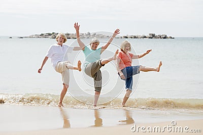 Group of three senior mature retired women on their 60s having fun enjoying together happy walking on the beach smiling playful Stock Photo