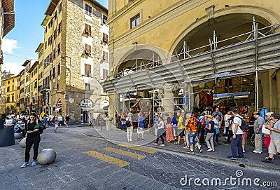 A group of tourists pass souvenir, leather and gift shops in Florence Italy Editorial Stock Photo