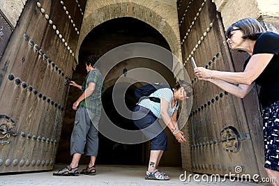 A group of tourists photographing the doors to the old grainaries of the Heri es-Souni in Meknes, Morocco. Editorial Stock Photo