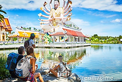 Group of tourists resting in the shade looking at giant buddhist temple in thailand Stock Photo