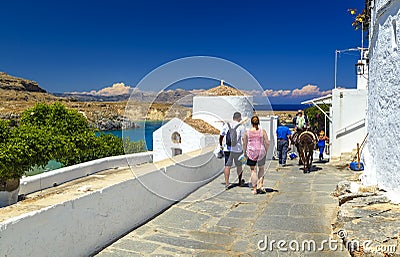a group of tourists strolling through the streets. Sea skyview landscape photo bay and orthodox church in Lindos on Rhodes island Editorial Stock Photo