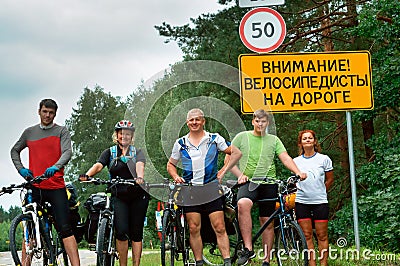 Group of travelers cyclists, road sign pointer, Belarus, Grodno, August 2017 Editorial Stock Photo