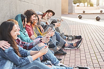 Group trendy friends using smart mobile phones outdoor - Millennial people having fun with new technology trends smartphone Stock Photo