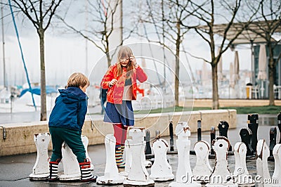 Group of two kids playing giant chess on playground Stock Photo