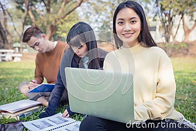 Group Of University Students asian sitting on the green grass W Stock Photo