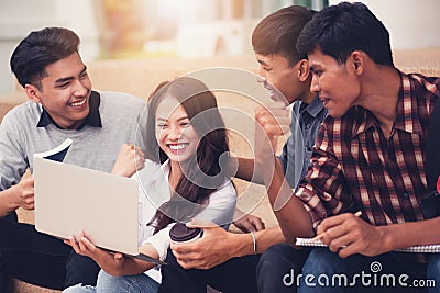 Group of university students smiling as they use laptop computer Stock Photo