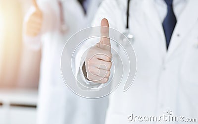 Group of unknown doctors standing as a team with thumbs up or Ok sign in hospital office, close-up. Medical help Stock Photo