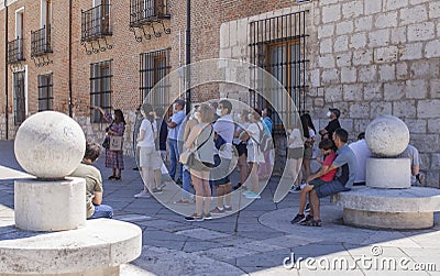 A group of unknown tourists with a professional tourist guide visiting the old city of Valladolid, Spain Editorial Stock Photo