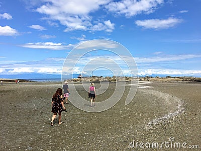A group of visitors exploring low tide and the ocean vistas of Kanaka Bay, on Newcastle Island, across from Nanaimo Editorial Stock Photo