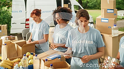 Group of Volunteers Preparing Free Food Rations for Poor People in Need. Charity Workers and Members Stock Photo