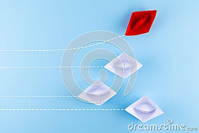 A group of white paper ship pointing in one direction and one red paper ship. Business behind an innovative solution concept Stock Photo