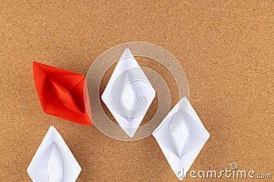 A group of white paper ship pointing in one direction and one red paper ship. Business behind an innovative solution concept Stock Photo