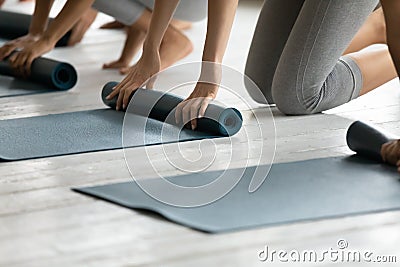 Group of women fold up mats after yoga work out close up Stock Photo
