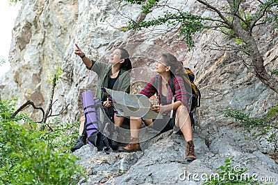 Group women lifestyle of hikers helping and checking map with backpack on a forest mountain. Traveler going camping. Stock Photo