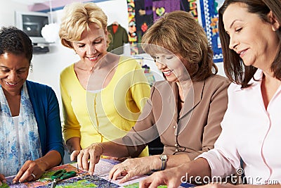 Group Of Women Making Quilt Together Stock Photo