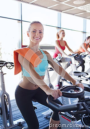 Group of women riding on exercise bike in gym Stock Photo