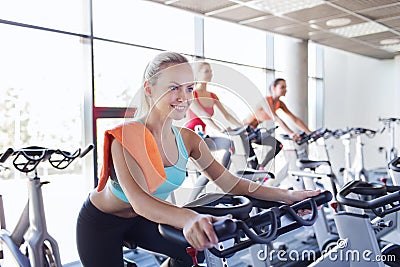 Group of women riding on exercise bike in gym Stock Photo