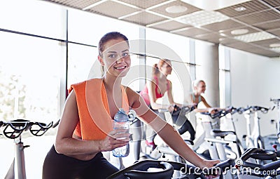 Group of women riding on exercise bike in gym Stock Photo